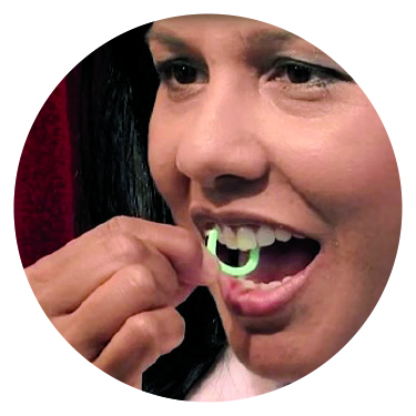 Woman using floss pick on upper teeth