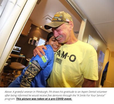 male veteran hugs female dental office worker at a charity event held by aspen dental